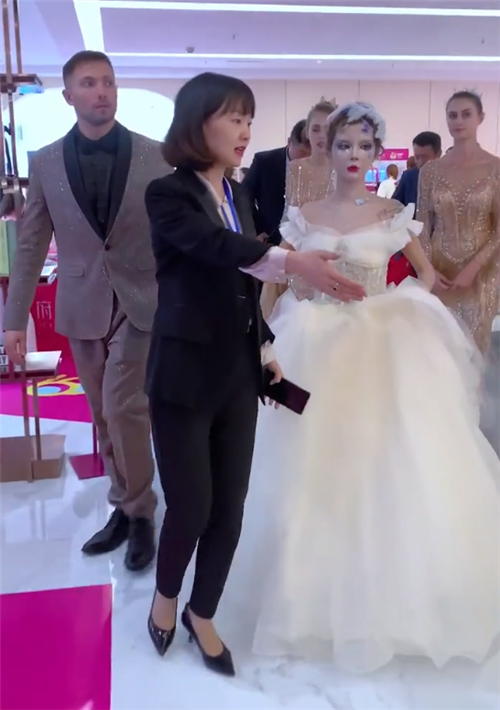 迪丽拉首次穿婚纱亮相,外国男士牵着她的手,身后数十位跟班抢镜