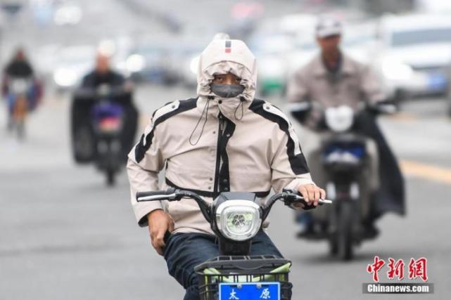 资料图：民众穿厚衣出行。武俊杰 摄