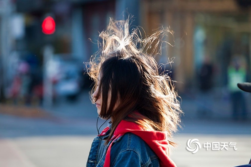 大风寒潮双预警 北京街头行人厚装顶风前行