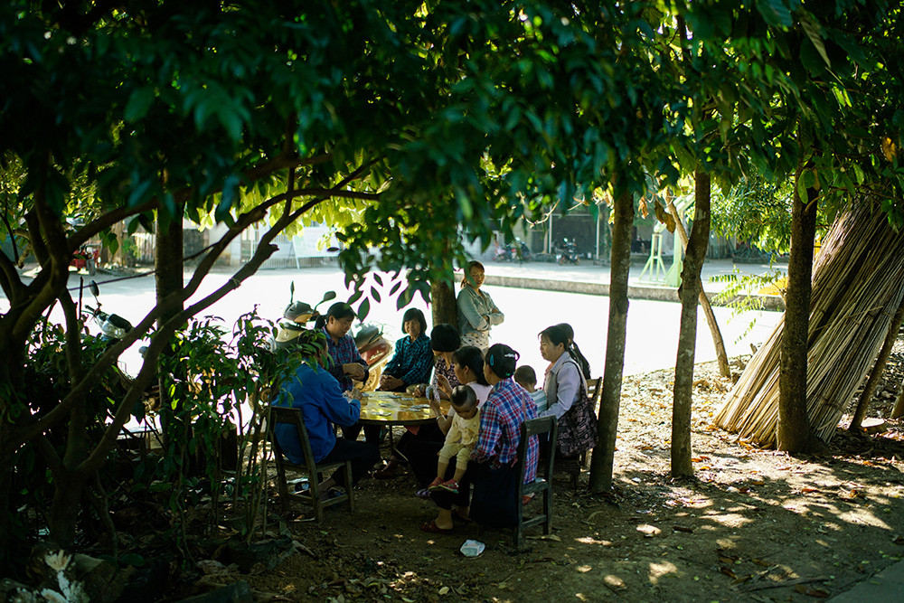 孩子们上学时,家长有时会在树下乘凉,打牌,等待他们放学.