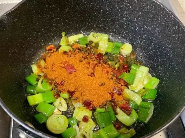 步骤2 取一口小锅,放入平时炒菜三倍的油,爆香葱花,然后放入麻辣烫料
