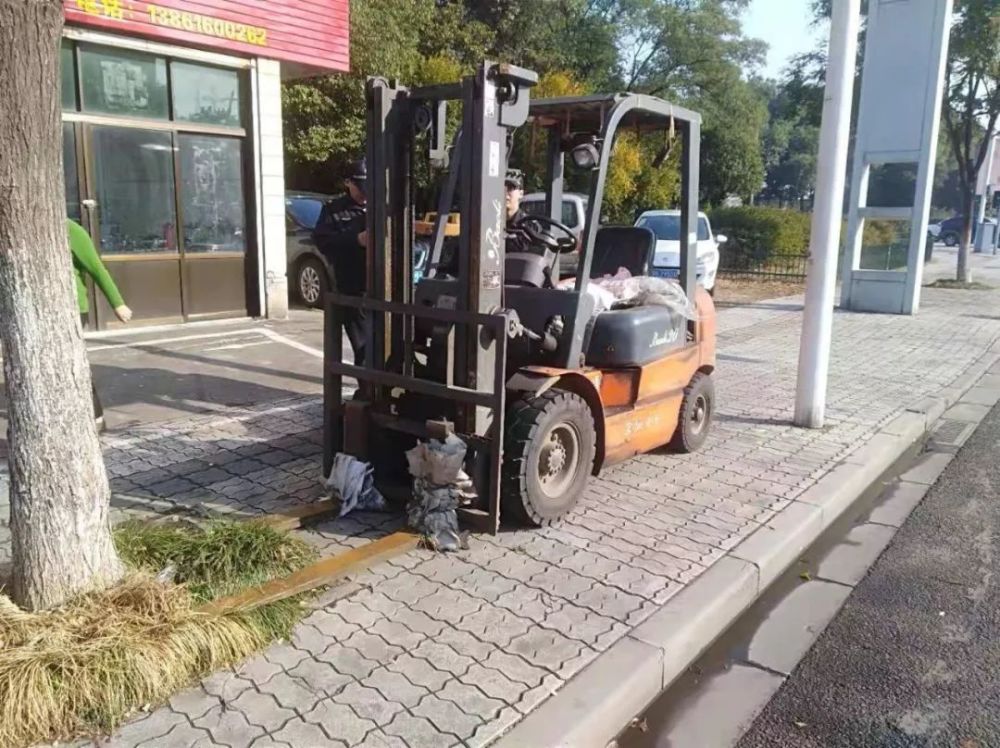 这样的场景是不是似曾相识 路边人行道上 停放着叉车