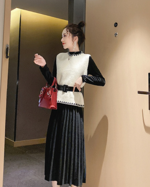 白色毛绒马甲搭配黑色长裙时尚感十足