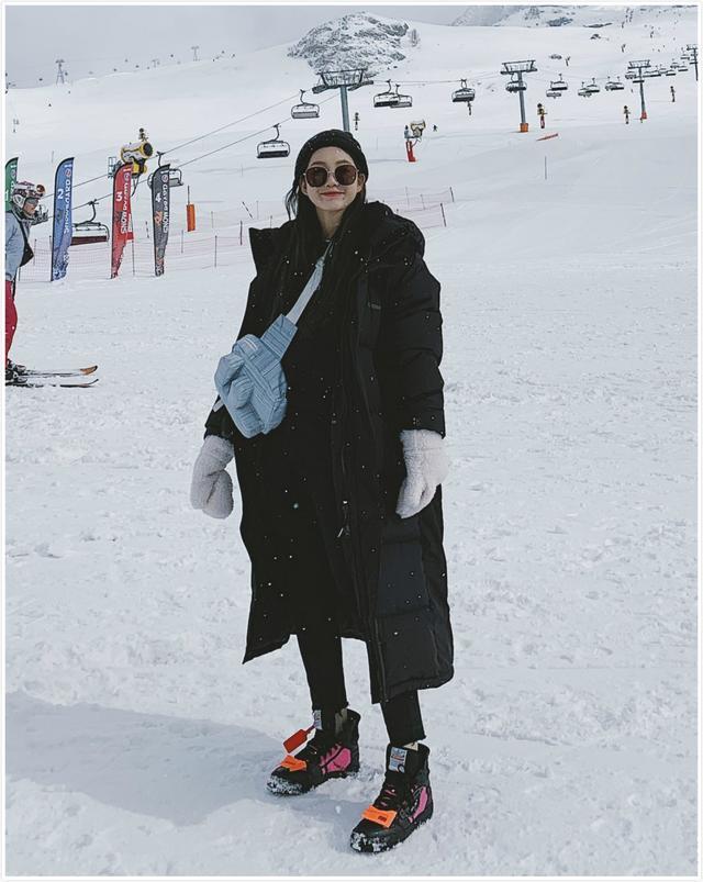 江疏影身穿黑色毛领羽绒服,搭配粉色针织套装,少女感十足.