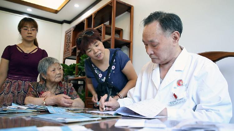 正在为病人问诊的老中医李配富随后,李配富接受了手术,通过中医制疗