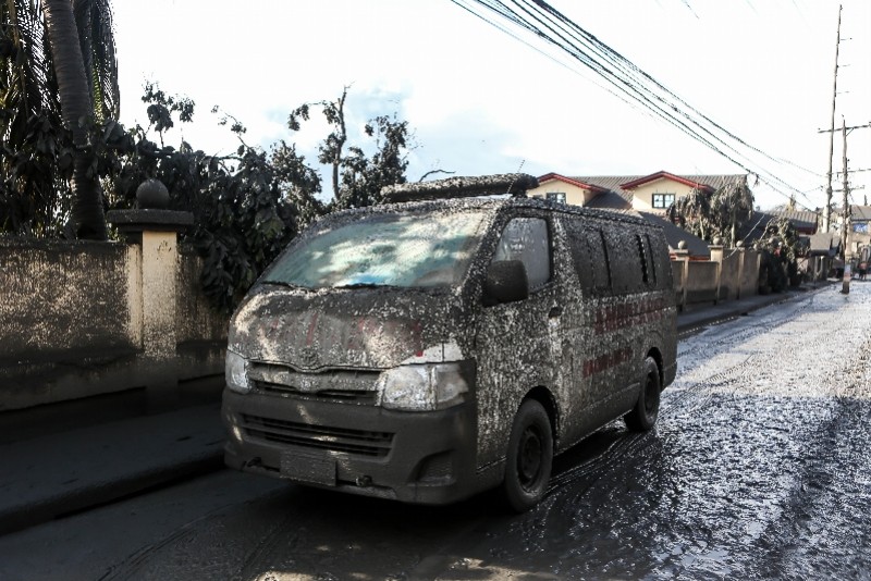 1月13日,在菲律宾八打雁省塔阿尔火山附近,一辆救护车被火山灰和泥浆