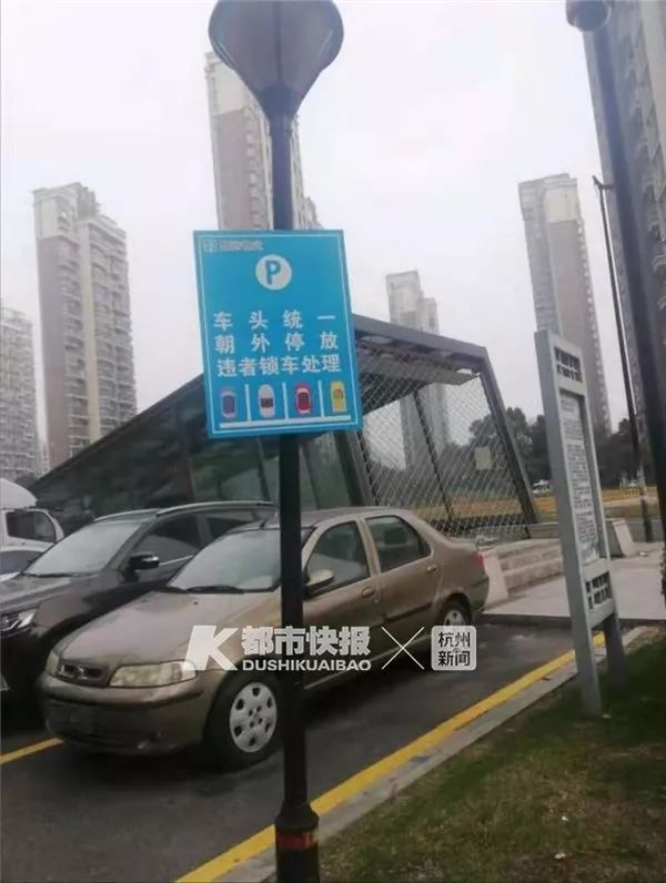 停车场指示牌上写着 "车头统一,朝外停放,违者锁车处理"