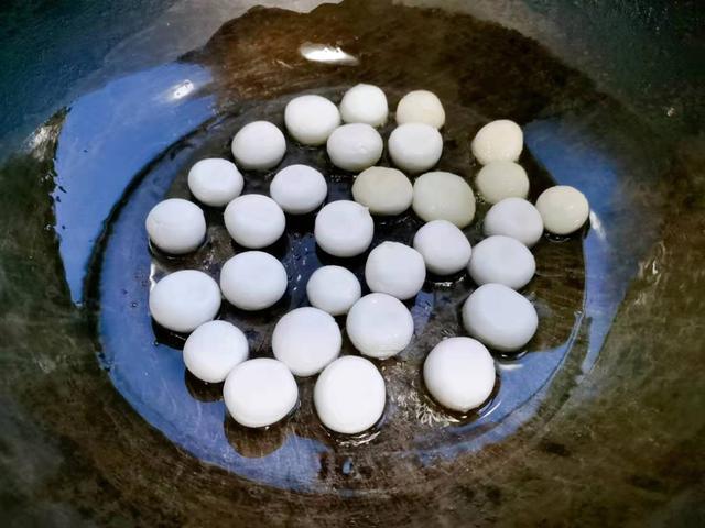 5,当锅中的汤圆煎制两面金黄时,倒入刚刚冲好的红糖水,先大火熬开,再