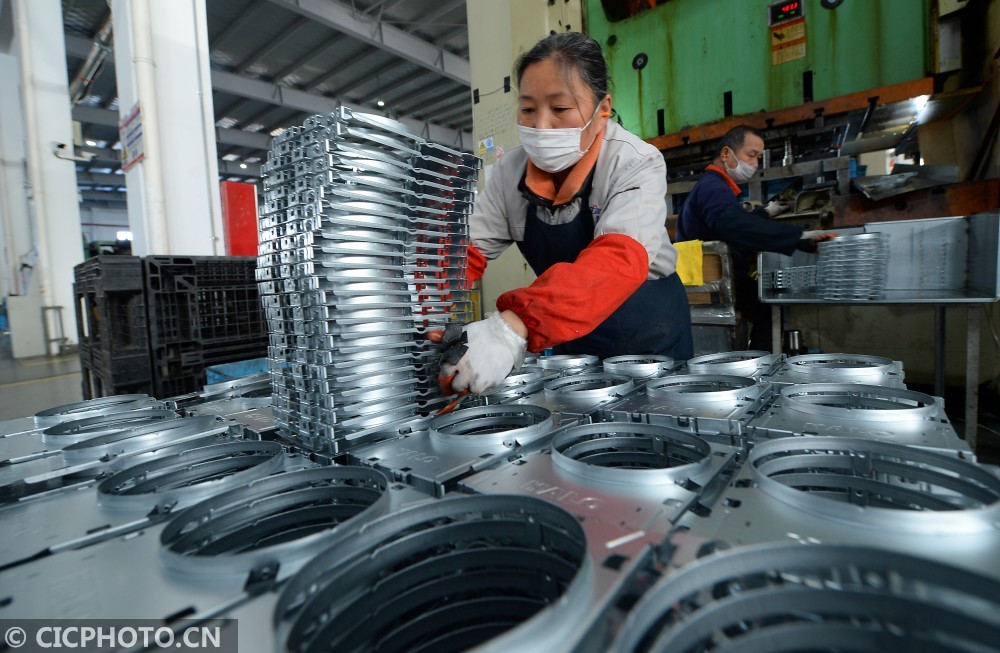 江蘇省蘇州太倉市璜涇鎮一家燈具製造企業內,女員工在衝壓車間加工