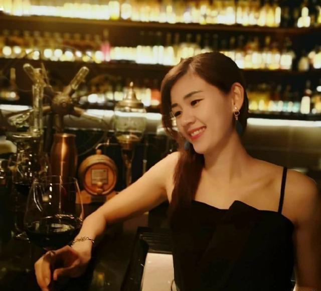 从照片中我们可以看到,温可微所处的背景应该是在一家酒馆,她穿着黑色