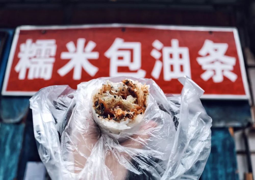 马蜂窝用户@我是你大王将糯米饭摊平在案板上,撒上配料,放上一根油条