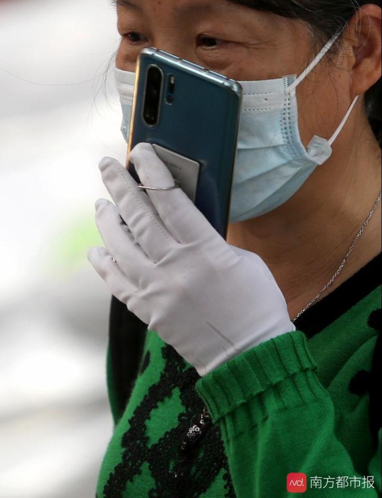 2月25日,广州新港中路,市民戴着口罩和手套发送微信语音.