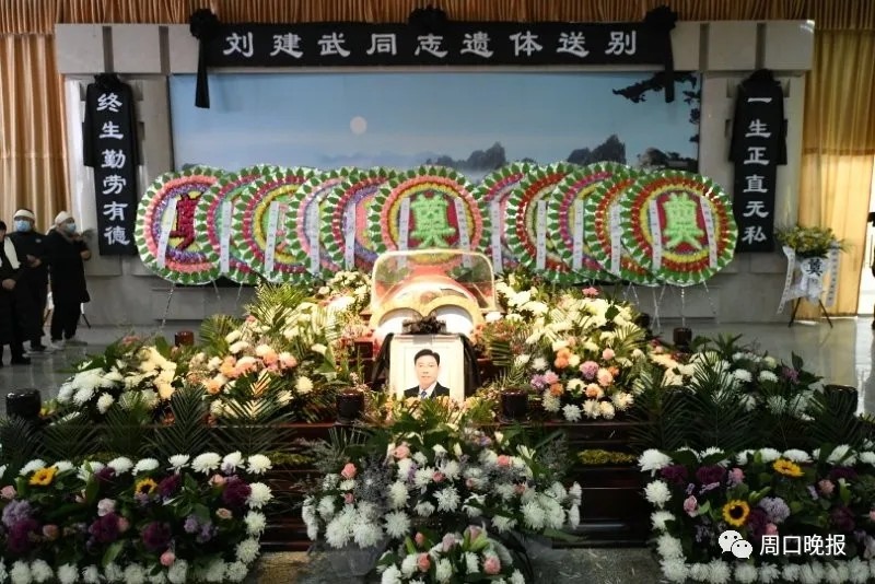 横幅"科学应对 群防群控 战胜疫情",内场鲜花环绕,以黑底白字写有挽联