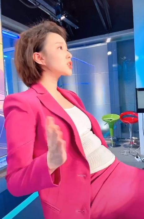 视频中,张美琪身穿玫粉色西装正装,妆容精致发型齐整,拍着肚子上的