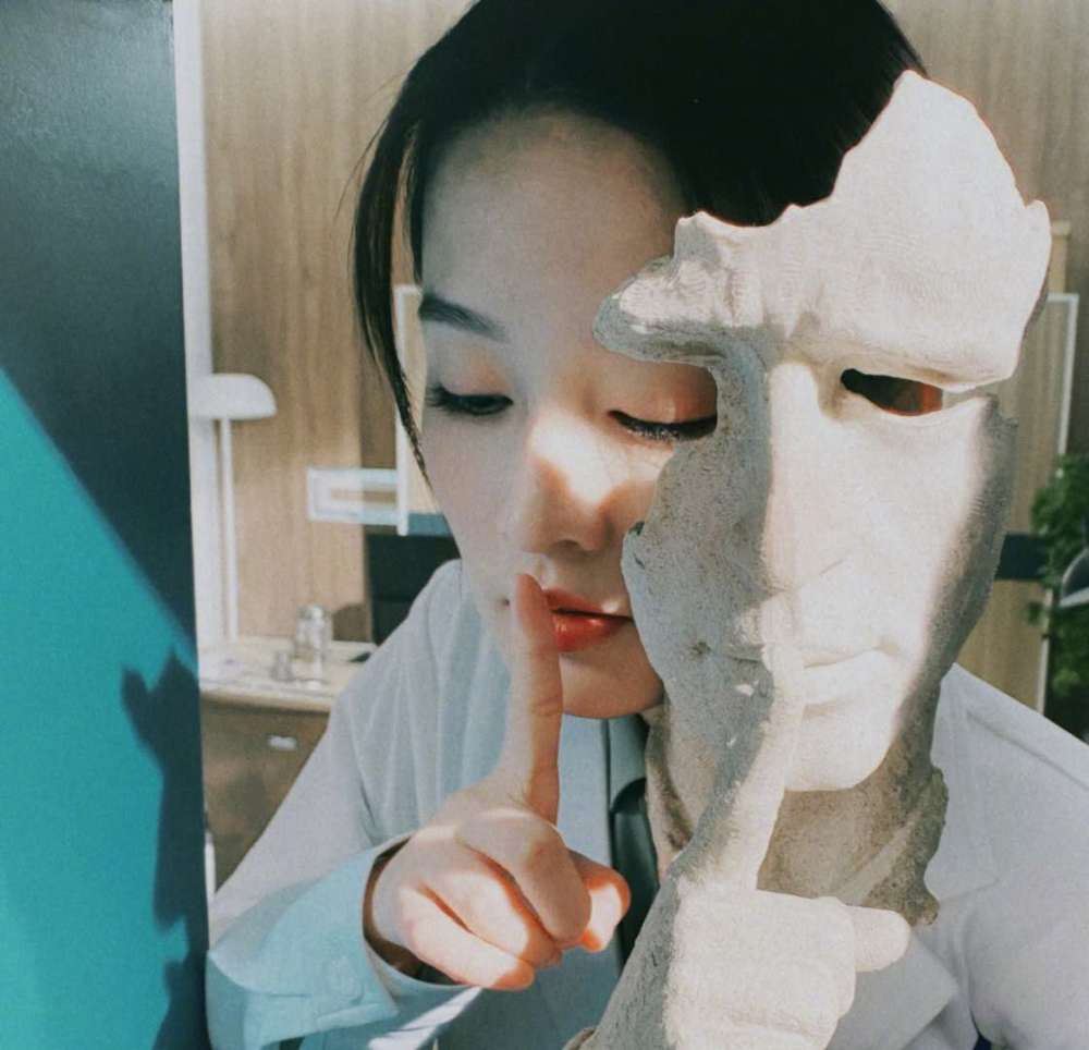 李沁模仿雕塑,手指放在嘴唇上,眼帘低垂含情脉脉,性感加倍
