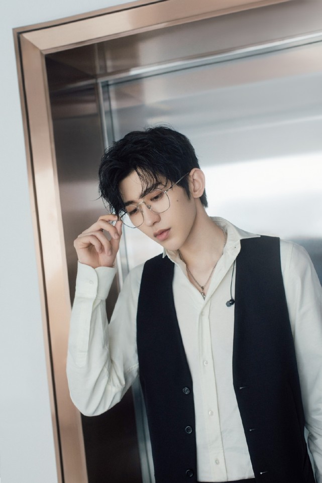 照片中,蔡徐坤身穿白色衬衣,外搭黑色夹克,戴着金丝眼镜,尽显斯文帅气
