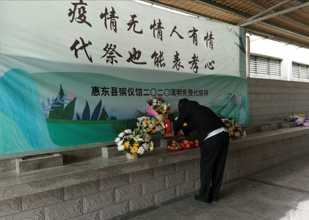 "4日上午,惠东县殡仪馆的祭拜台上摆满了鲜花,果盘,一名身着黑色西装