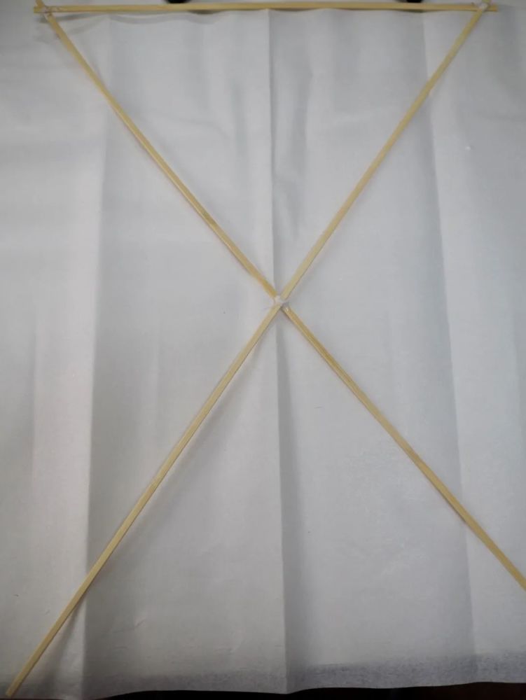 瓦片形风筝的骨架是用三根竹条拼成的一个"又"字.