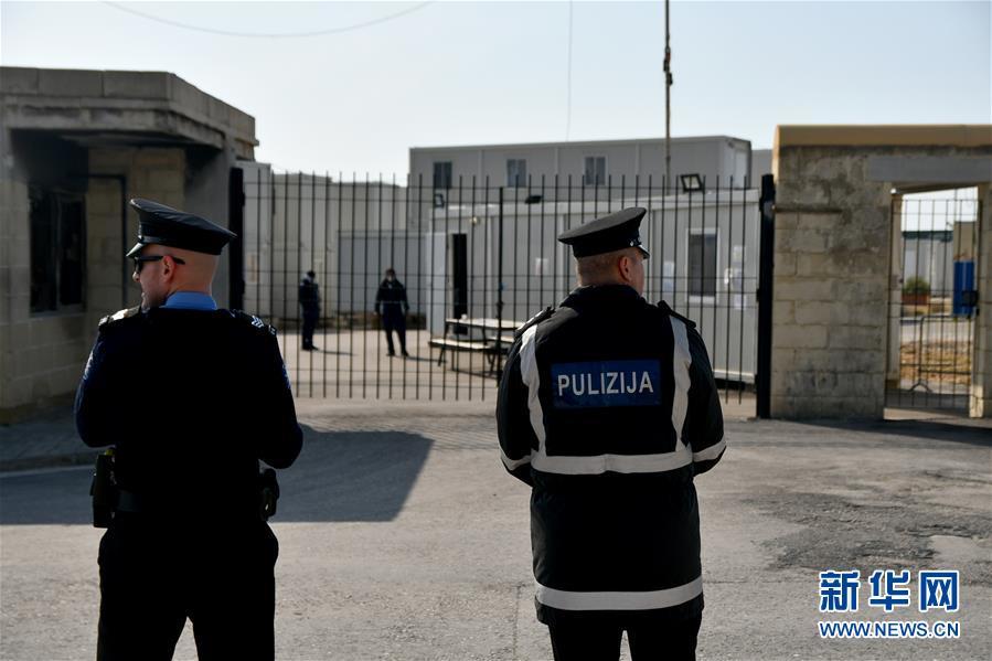 4月6日,在马耳他南部的比尔泽布贾,两名警察站在难民营外.