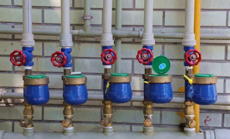 看到每栋居民楼下都整齐地排列着10个新安装的水表,一个水表对应一户