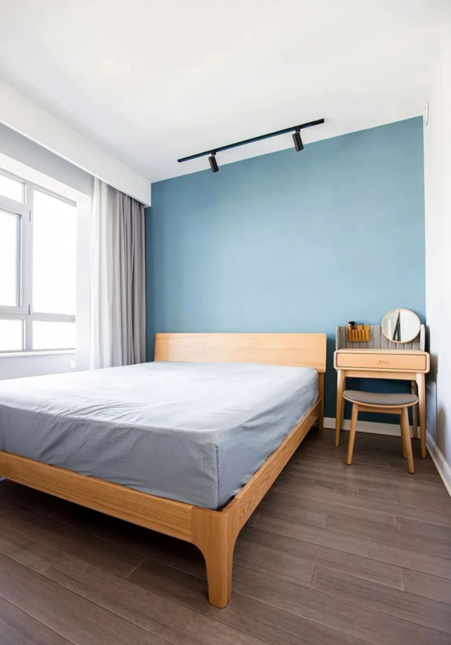 主卧,将客厅天蓝色墙面也延伸到这里,床头摆放着精致的梳妆台,没有
