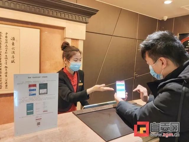 图:汇东大酒店前台服务人员向刚到店的外地客人讲解"防疫健康信息码"