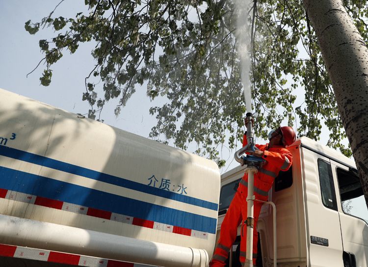 4月14日,花乡桥南四环辅路,丰台园林工作人员用高压水炮清理杨絮.