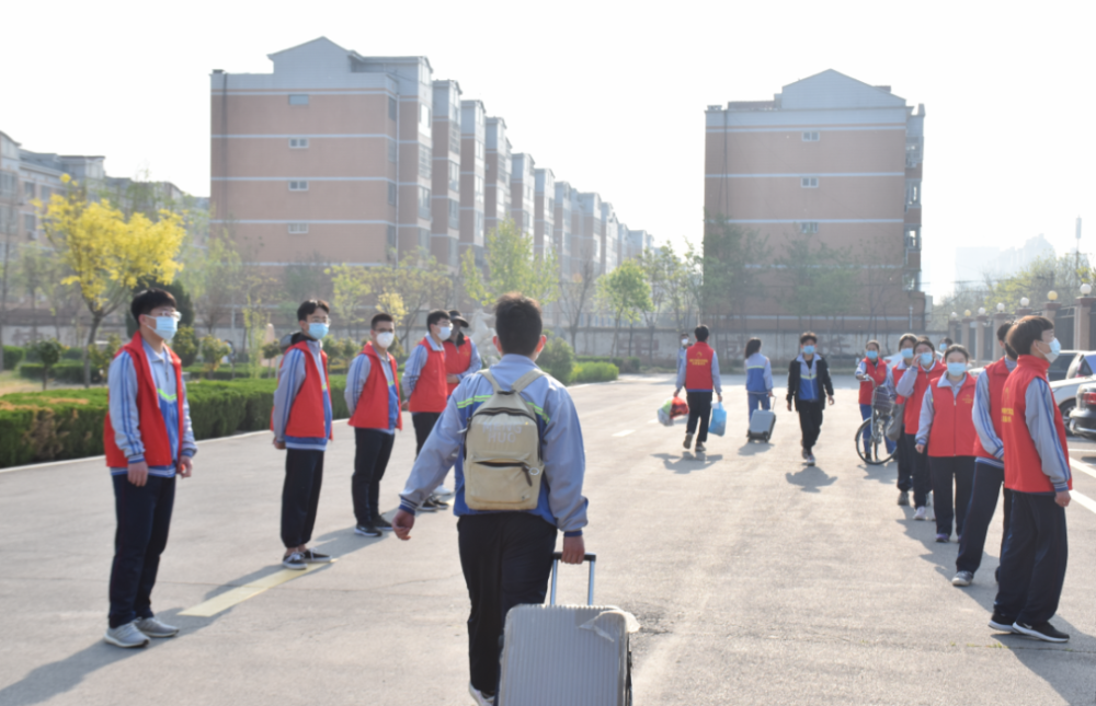 冠县实验高级中学学生间隔好距离,进行健康表登记,测量体温后有序入校