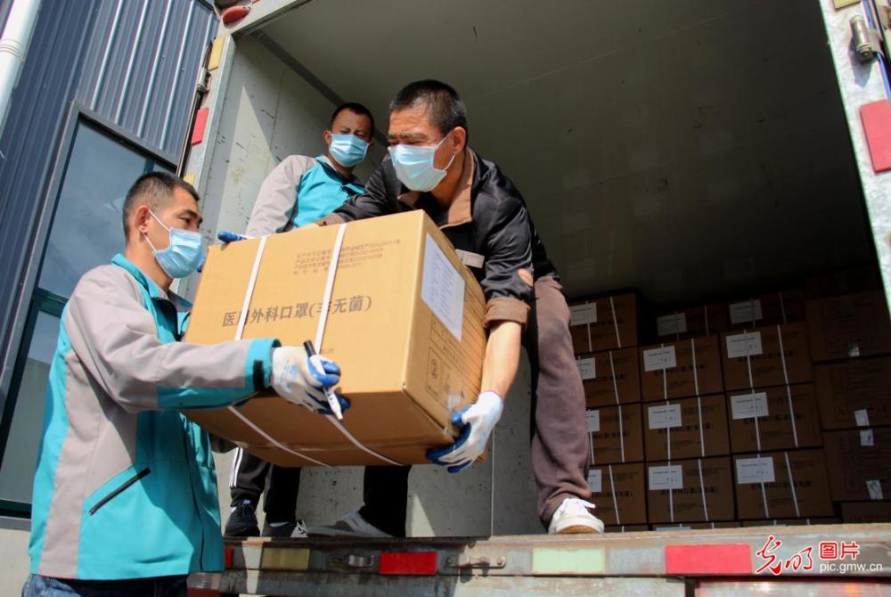 2020年4月21日,工人正在将出口的口罩装车.