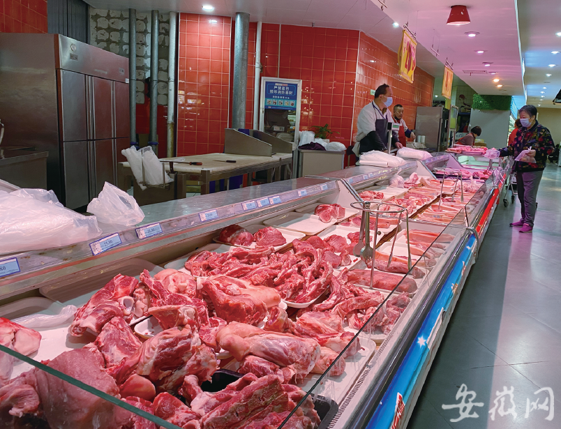 蜀山区某超市,顾客在挑选猪肉.