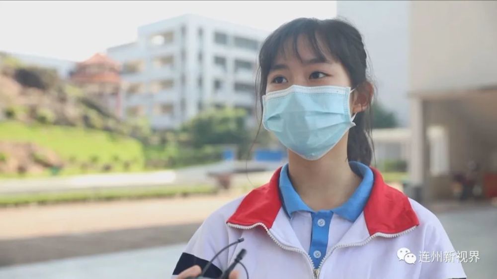 等待入校门的学生们身穿校服,面戴口罩,没有久别重逢的热情相拥,亲密