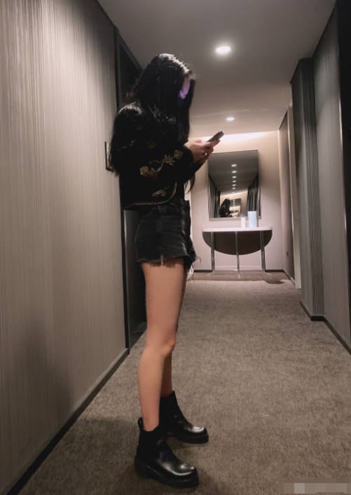 脚蹬一双皮靴,大长腿一览无遗,披散的长发遮住了脸,从侧面来看身材