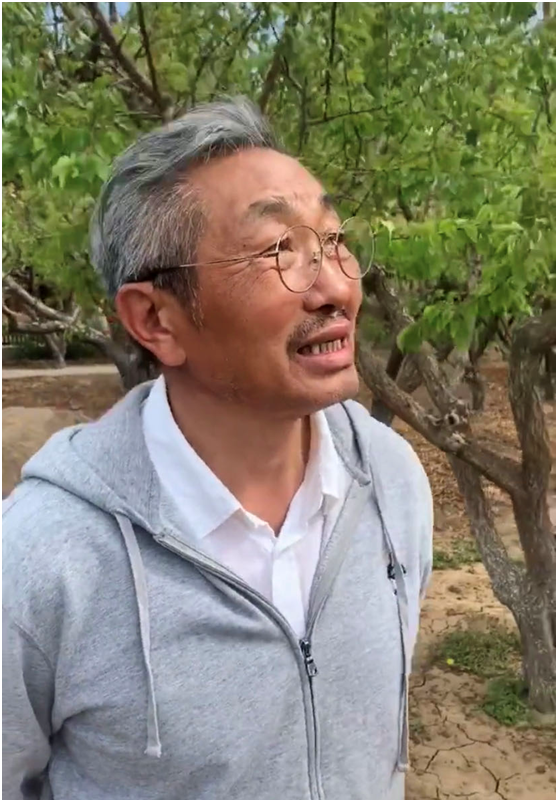 视频中,杜源身穿灰色的运动卫衣和内搭一件白色的衬衫,戴着圆框眼镜在