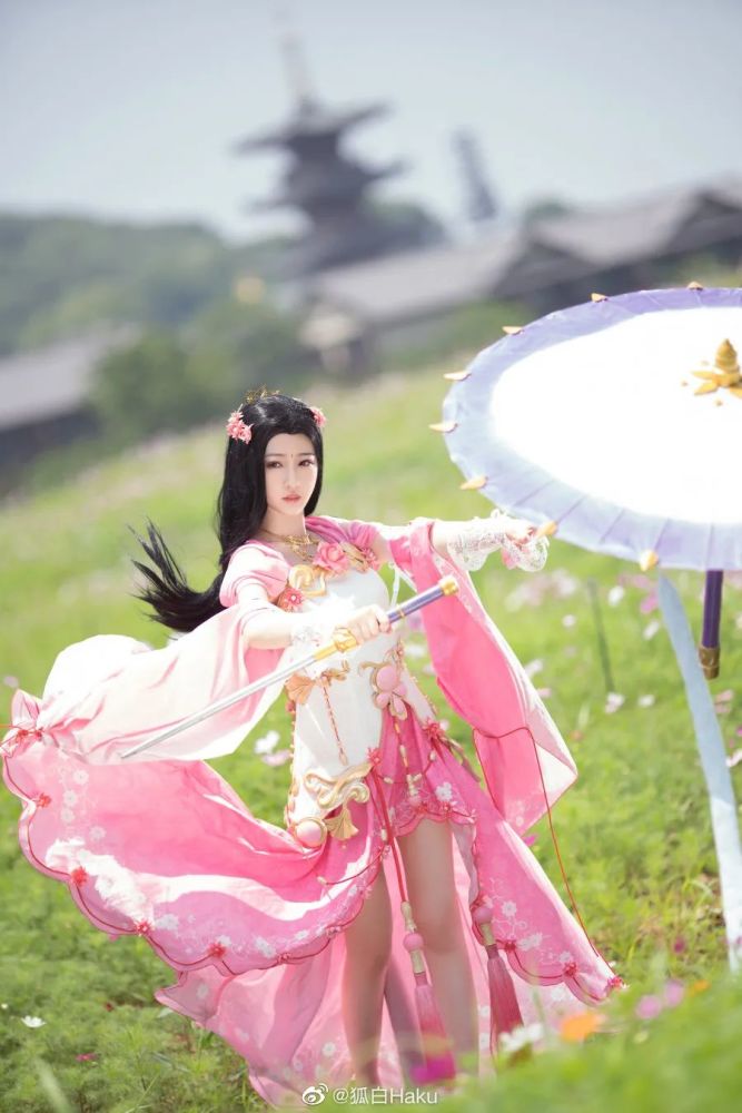 她一手持伞,一手持剑,手腕翻飞耍出一朵漂亮的剑花.