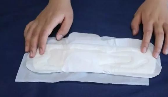 首先将卫生巾打开,再准备一瓶花露水,把花露水打开滴在卫生巾上面,将