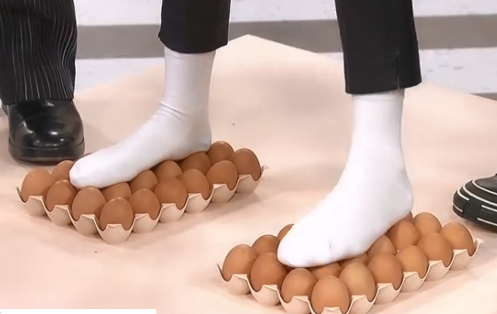 而是她一个脚上就踩了整排的鸡蛋,她脚踩到的鸡蛋就有12个了,所以受力