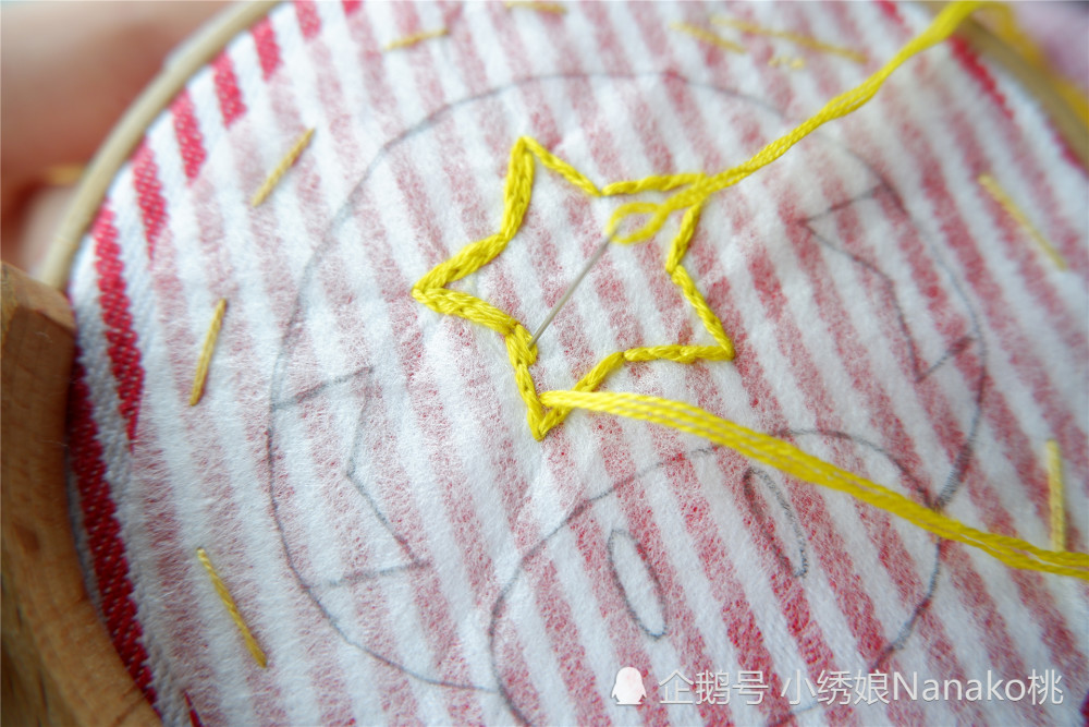 选择黄色绣线4股,从五角星的顶点出针,使用裂线绣针法,先沿着轮廓刺绣