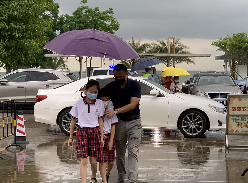 副校长汪晨曦雨中护送孩子们入校.