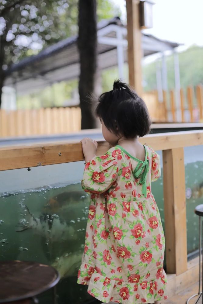 小金鱼隔着深蓝的玻璃, 与踮起脚尖的小女孩咕噜咕噜地说着水里的小