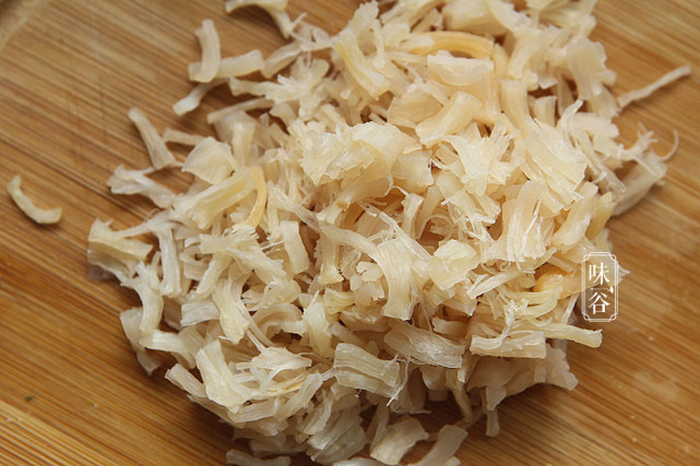 4,锅内放入适量油,放入蒜蓉炒香,然后倒入干贝丝,用小火炒香,干贝本来