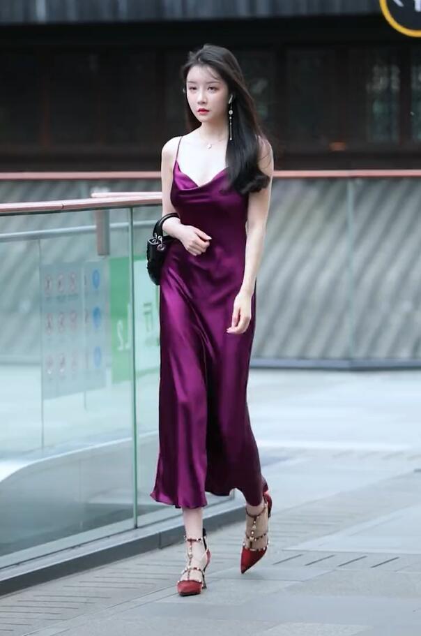 图上这位美女行走在街角 , 一身紫色的连衣裙 , 烘托出她高贵的气质 .