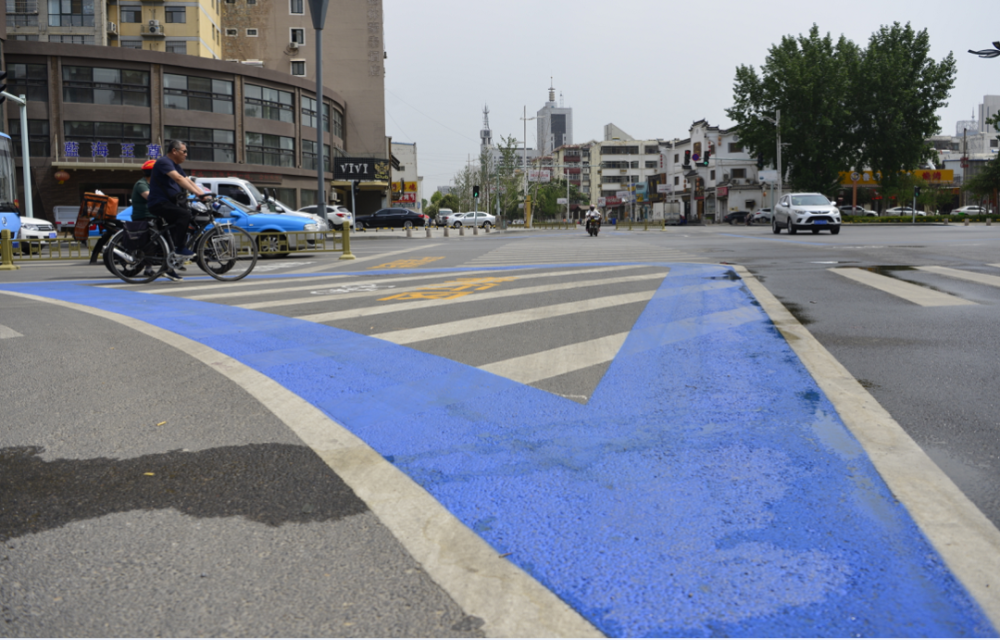 分别施划非机动车"二次过街"等待区,在路口内,人行道外侧规划非机动车