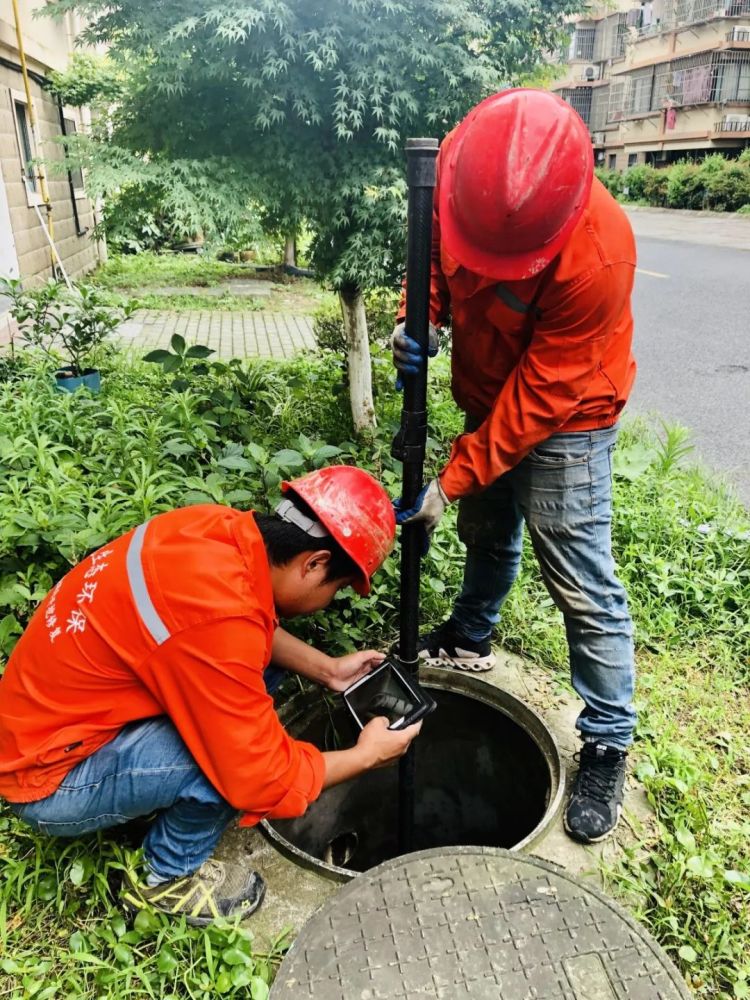 9名工作人員分3組,正用管道內窺攝像檢測儀器,對地下汙水管網內部是否