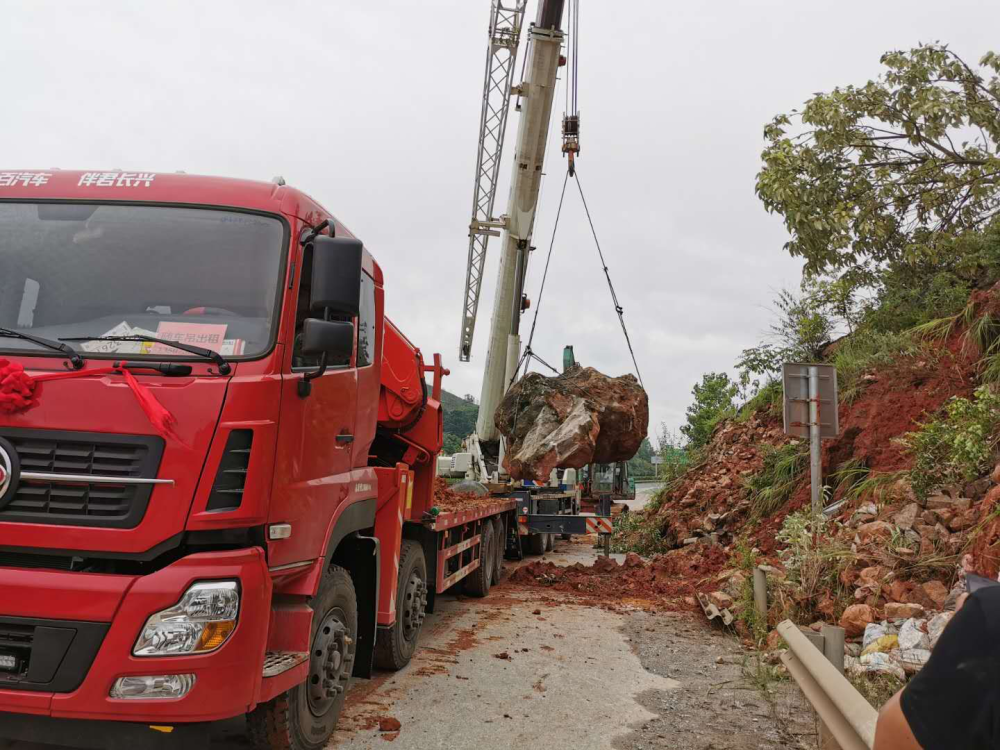 连续降雨导致高速边坡垮塌巨石侵占路面高速养护部门用吊车运走巨石