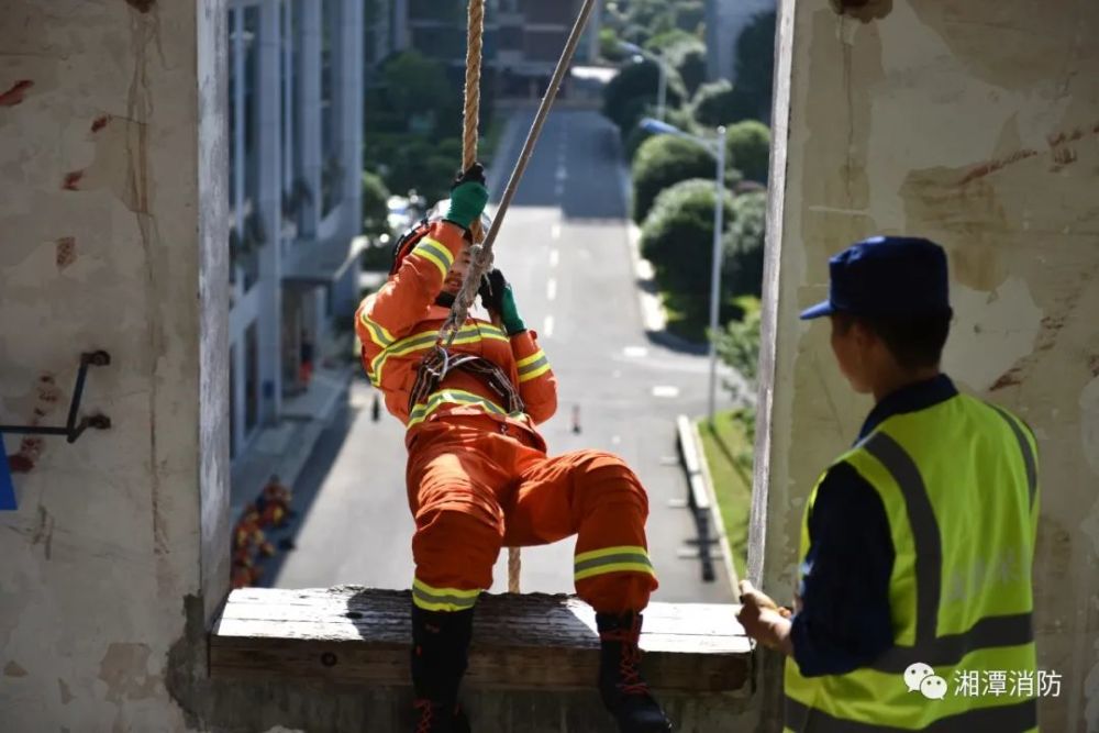 训练塔上,队员们双手握绳,两手交替屈臂上拉,身姿矫健,勇攀高峰.
