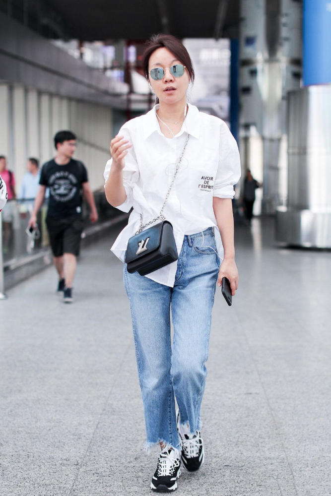 被闫妮惊艳到了!白衬衫配牛仔裤素颜走机场清爽减龄,哪像49岁
