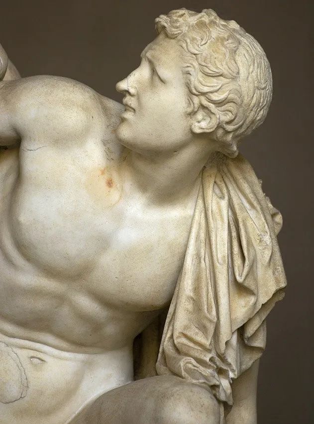 拉奥孔的幼子几乎被蛇卷倒,他举起左手企图呼救,右手无力地抓着咬住他