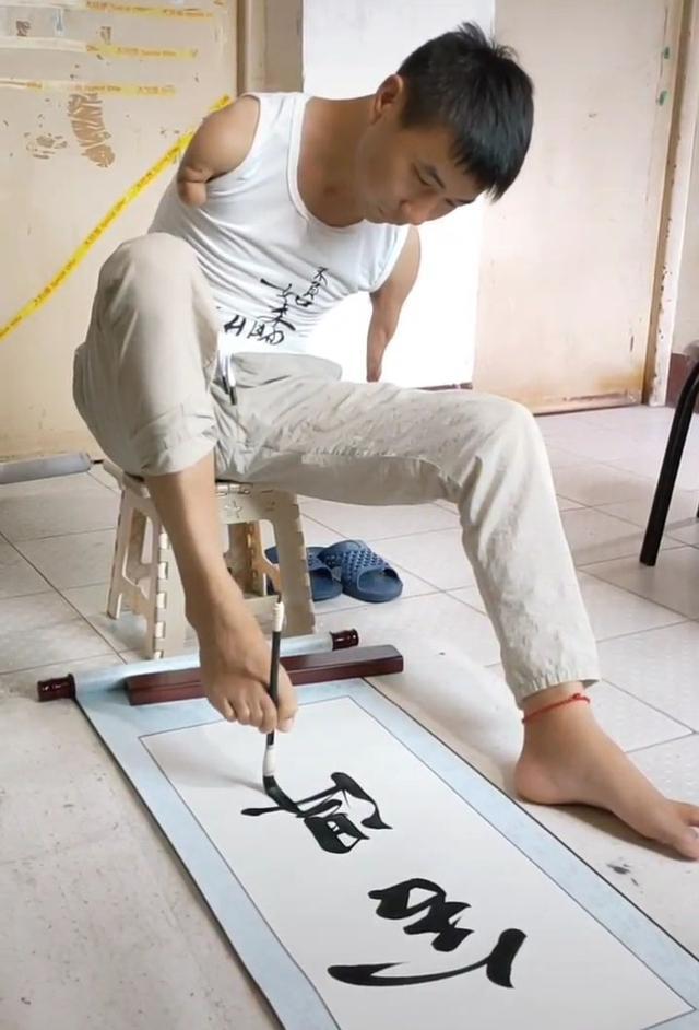 他被网友称之为无臂励志哥用脚书写地摊书法笔笔惊艳