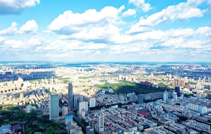 在蓝天白云的映衬下,长春市城区高楼林立,绿地葱茏,相映成景