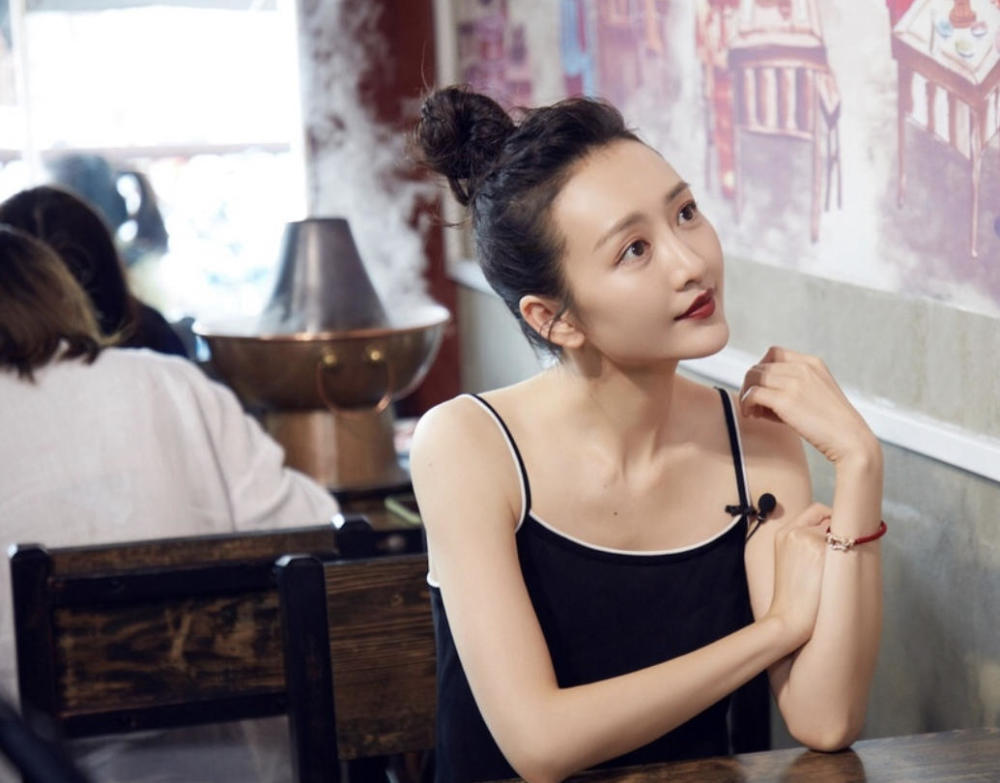 王鸥气质全开,扎高高的丸子头发型配黑色吊带连衣裙,女神范十足